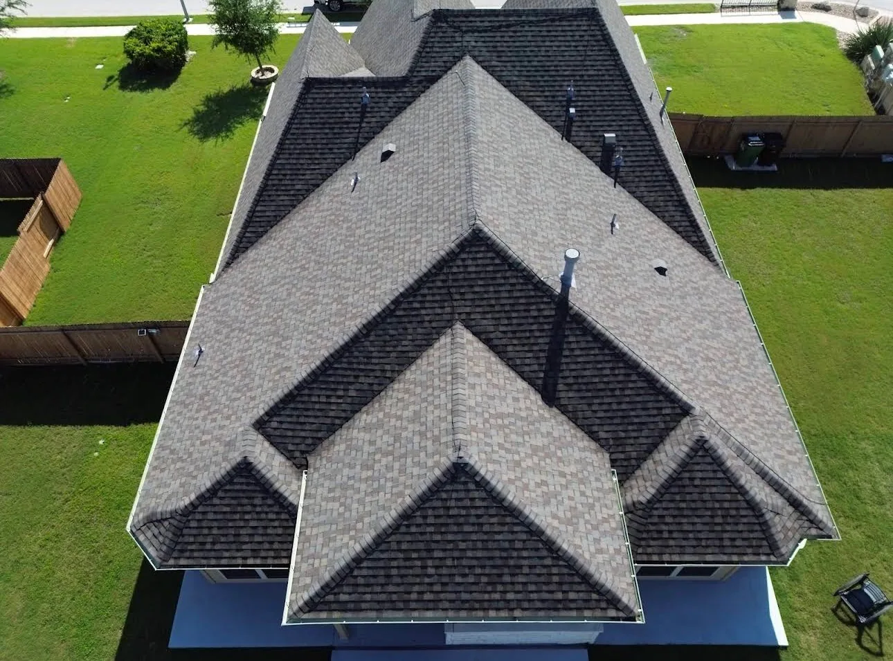 Aerial layered hip roof brown blend shingles, Hutto, TX