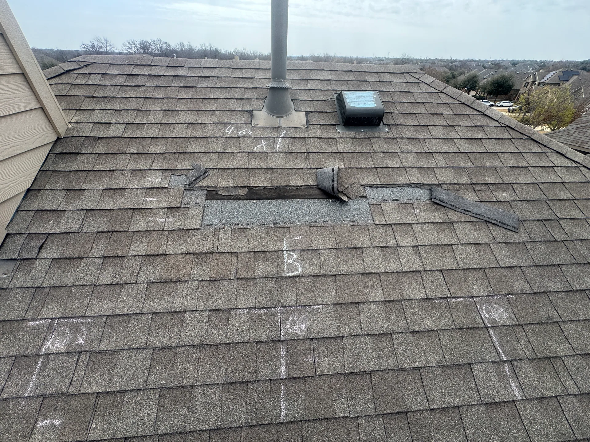Lifted creased shingles below vent pipe, Hutto, TX