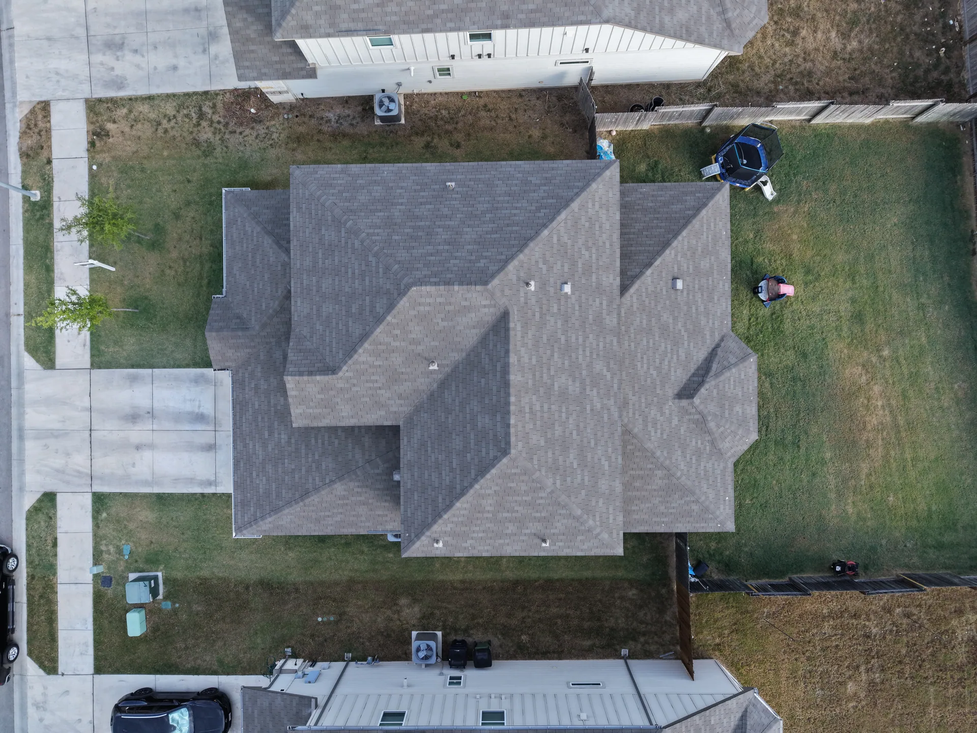 Overhead gray shingle roof fenced backyard, Hutto, TX