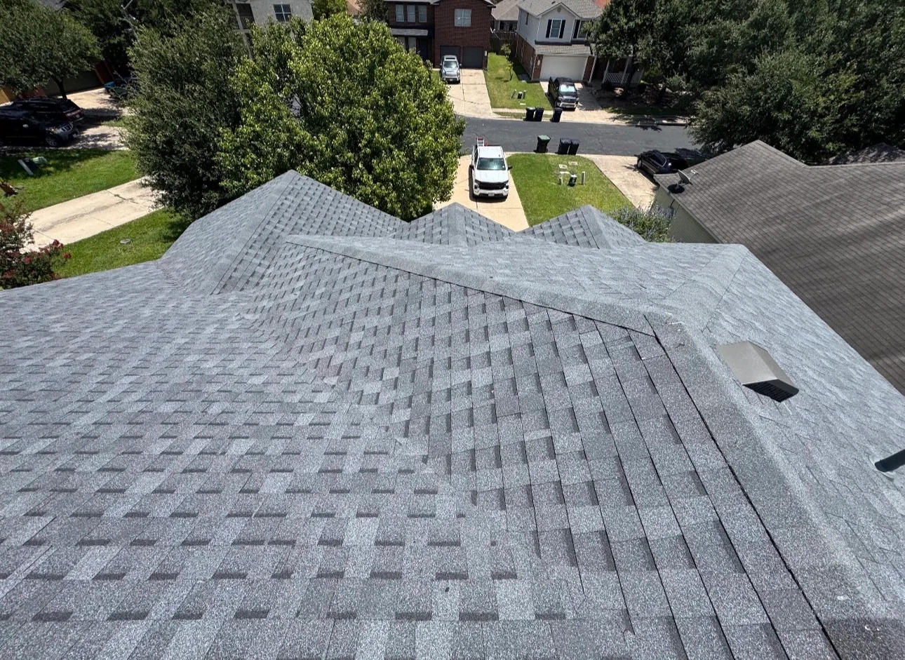 Rooftop new gray shingles beside aged neighbor roof, Hutto, TX