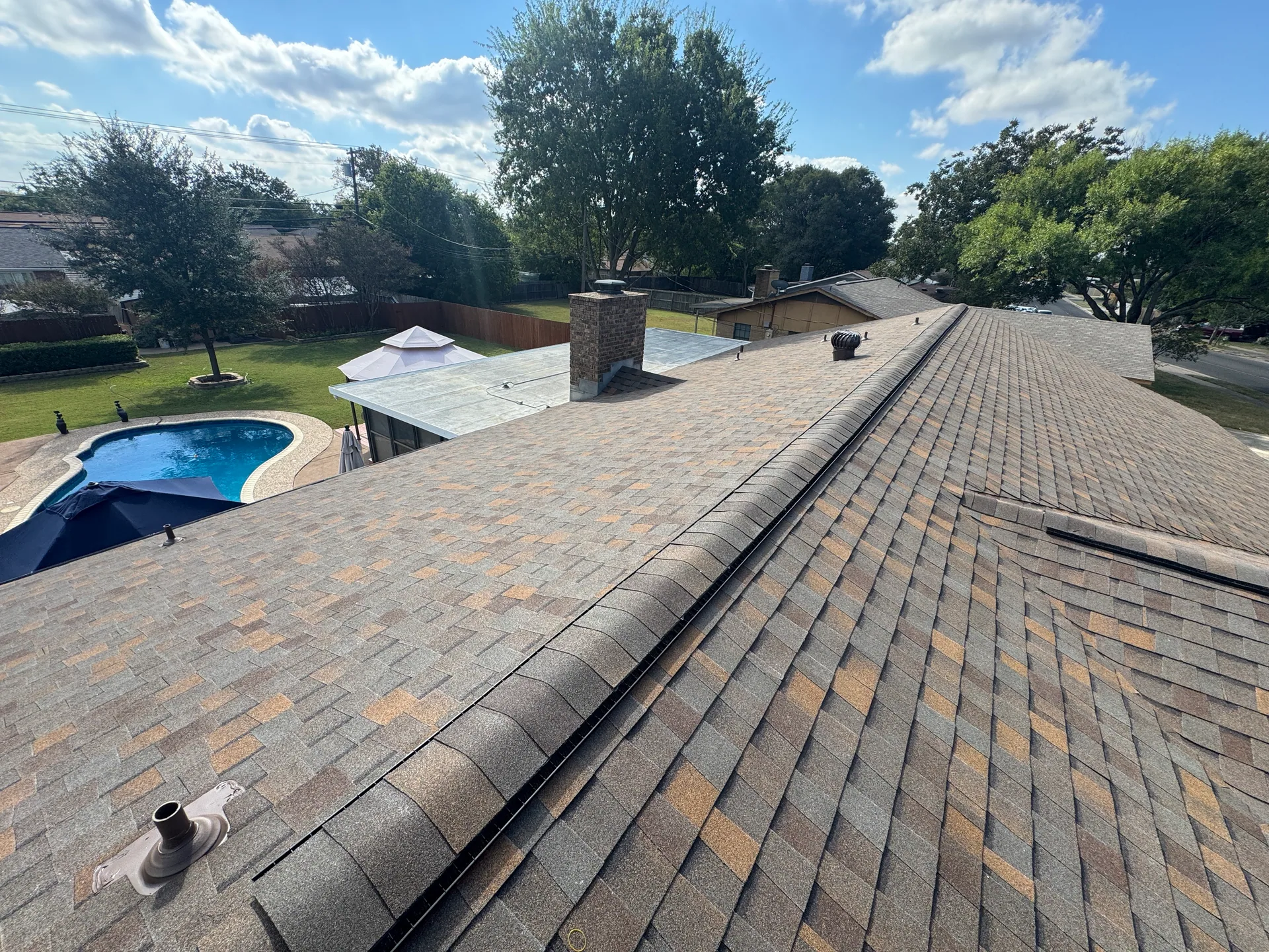 Rooftop ridge cap tan shingles chimney pool, Hutto, TX